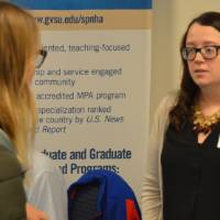 An alumna and student talking at the Academic Major Fair.